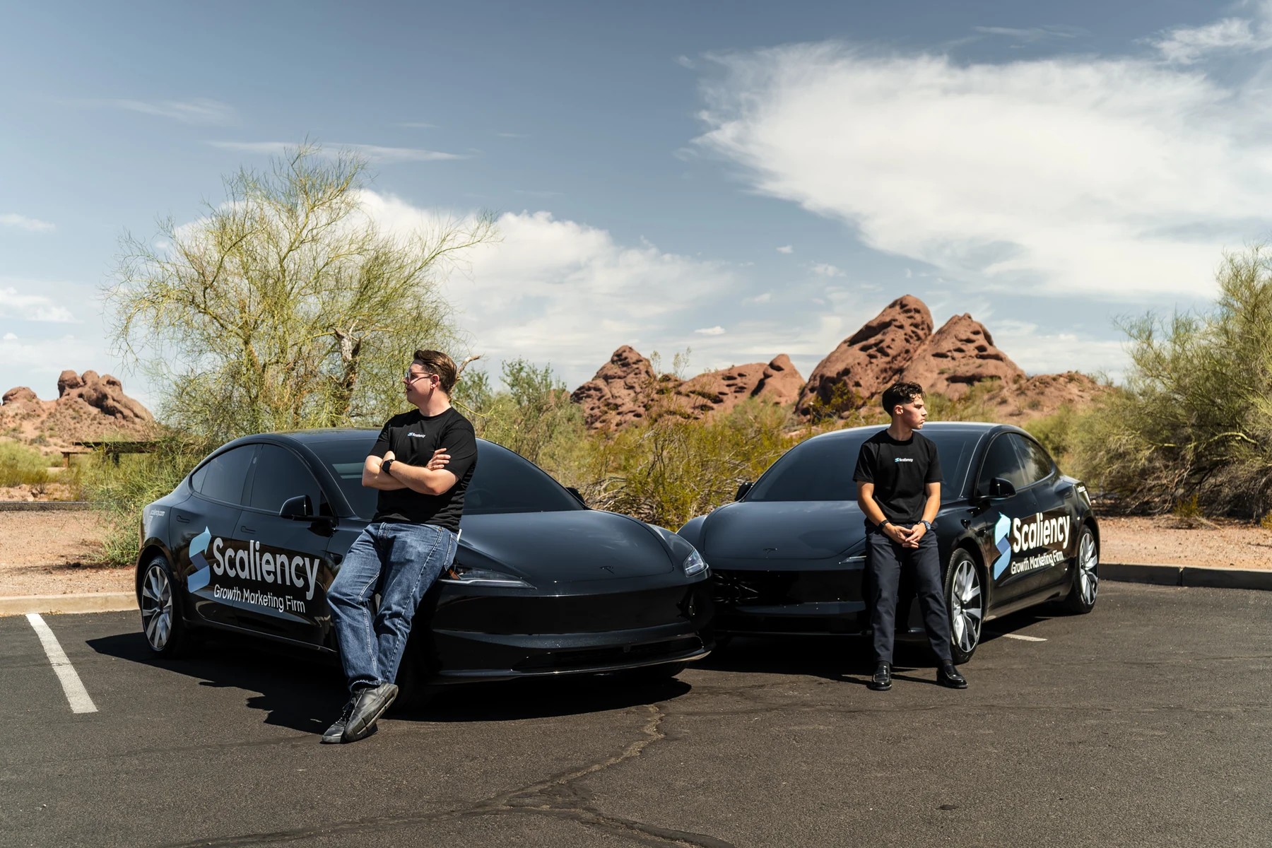 Oscar and Cesar leaning on the wrapped Scaliency cars in Phoenix